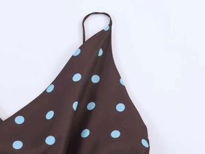 Close-up detail of thin straps and blue polka dots on a brown summer camisole top