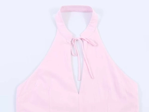 Detail of pink halter neck top showing the V-neckline and tie strings on woven fabric
