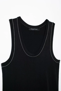 Detail of black knit tank top featuring contrasting white stitching and deep U-neckline