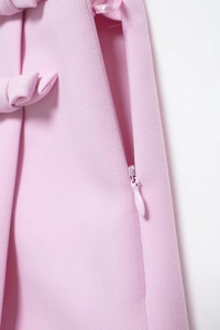 Détail de l'ensemble dos nu rose montrant la fermeture éclair invisible et le nœud