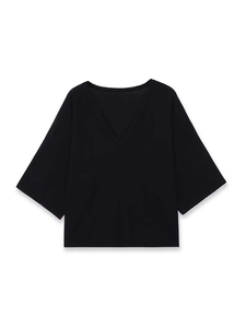 Dettaglio di un top in maglia nera con scollo a V profondo e maniche a tre quarti ampie