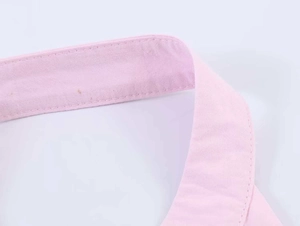 Detail of the pink poplin halter neckline showing precise double-stitch sewing quality