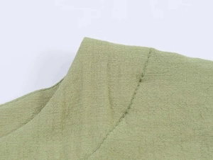 Nahaufnahme der Schulternaht an einem grasgrünen Strickshirt mit Puffärmeln