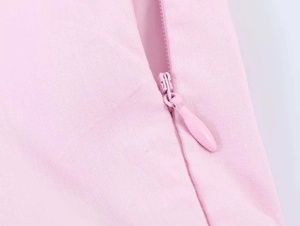 Detailed macro view of a pink poplin dress featuring a seamless concealed zipper closure