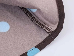 Detailed close-up of brown vintage camisole with blue polka dots and neat stitching