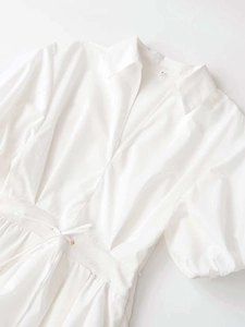 Detail of white cotton mini dress with puffed sleeves and elastic drawstring waist