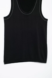 Detailed close-up of white contrast stitching on a black knitted tank top for women