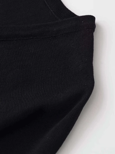 Dettaglio di maglia a coste nere che mostra la trama fine e le cuciture di qualità
