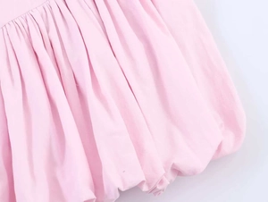 Detailed macro view of pink cotton fabric featuring dense pleats and bubble hem design