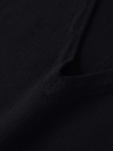 Dettaglio dello scollo a V su top in maglia nera con trama fine e cuciture di qualità