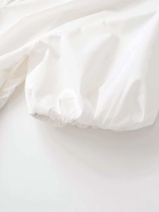 Close-up of white poplin mini dress featuring elastic pleated lantern sleeve detail