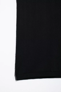 Detail of black knit top featuring flat stitch texture and white contrast side stripe