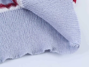 Detailed close-up of light blue rib-knit fabric with red and white horizontal stripes