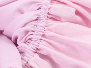 Detailed view of elastic smocked pleats on pink poplin halter dress fabric