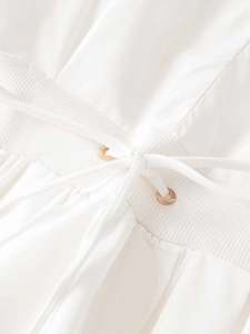 Detail view of white poplin dress waist with gold eyelets and adjustable drawstring tie