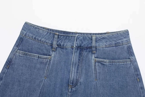 Detail of high-waisted blue denim skirt featuring orange stitching and belt loops