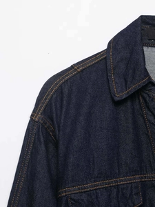 Detail of dark blue denim jacket showing collar, shoulder stitching and yellow contrast seams