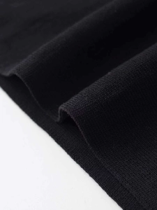 Dettaglio della trama in maglia nera con motivi a trama fine su questo top elegante