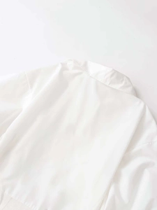 Close-up detail of white V-neck poplin dress neckline with smooth ribbed finish