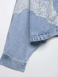 Detail of light blue denim jacket featuring delicate white floral lace patchwork sleeve