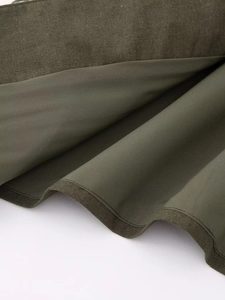 Gros plan détaillé sur le tissu du gilet brodé vert olive et sa doublure lisse