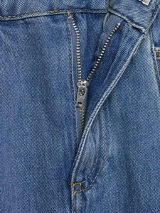Macro detail of high-quality blue denim fabric with silver zipper and contrast stitching