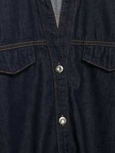 Detail of dark blue denim jacket featuring chest pockets with orange contrast stitching