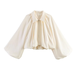 Detailed view of cream satin jacket with balloon sleeves and smooth zipper closure