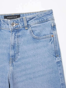 Détails d'un jean bleu clair à taille haute montrant la poche et les coutures