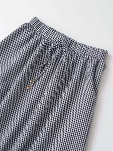 Close-up of gingham skirt elastic waist with drawstring and gold metal bead details