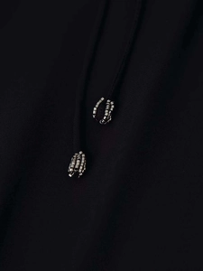 Close-up of black shirt drawstring with intricate silver metallic cube beads detail