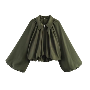 Detail of olive green jacket featuring balloon sleeves and a zippered cropped hem design