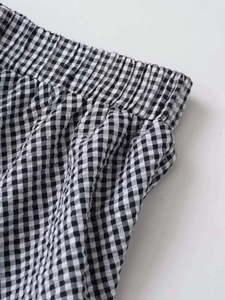 Detail view of black and white gingham skirt featuring elastic smocked waistband