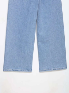 Détail du tissu denim bleu clair et surpiqûres à double aiguille sur jean taille haute