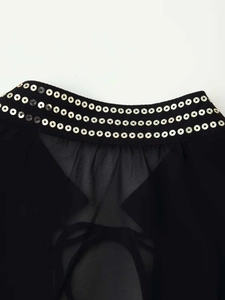 Detail of sheer black shirt featuring three rows of gold round sequins and pleats