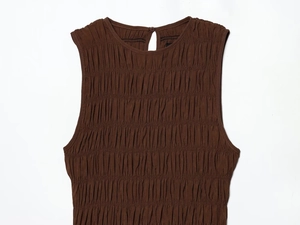 Close-up of brown sleeveless dress with smocked texture and back button detail