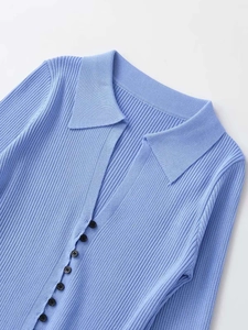 Detail view of light blue ribbed knit cardigan with Polo collar and brown buttons