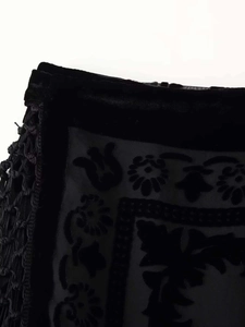 Makrodetail aus schwarzem Samtstoff mit aufwendiger Blumenhäkelarbeit und Spitzenstickerei