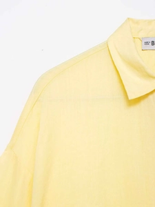 Close-up of light yellow shirt featuring cotton-linen texture and classic collar detail