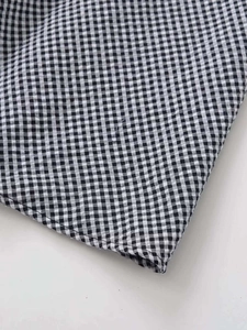 Detailed close-up of black and white gingham fabric with high-quality stitching detail