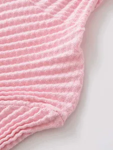 Vista macro dettagliata della trama in maglia a nido d'ape rosa e cucitura dell'orlo