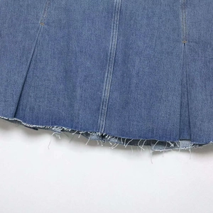 Fashionable blue denim skirt with trendy pleated details and a vintage raw fringe hemline