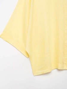 Close-up of light yellow shirt showing breathable textured fabric and dropped shoulder sleeve