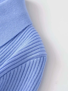 Close-up of light blue knit fabric showing detailed vertical ribbing and seam texture