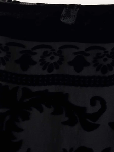 Detailaufnahme des schwarzen Burnout-Samtstoffs mit Blumenmuster auf einem Wickelrock