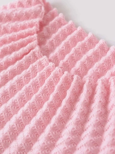 Dettaglio della trama a maglia rosa con motivo a coste ondulate per abbigliamento donna