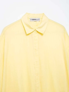 Detail of light yellow breathable shirt collar featuring a woven brand tag and size label