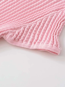 Dettaglio del tessuto a maglia rosa con trama ondulata e rifiniture di cucitura precise