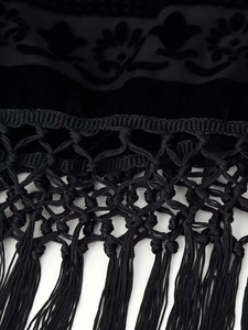 Makroaufnahme von schwarzem Burnout-Gewebe mit Knotengeflecht und Fransen-Tassel-Saum