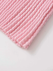 Macro di tessuto a maglia a coste rosa che mostra la trama fine e l'armatura elastica